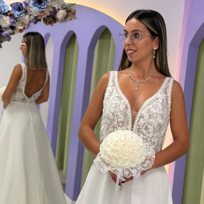 Vestido de noiva branco com renda floral e ramo de flores brancas