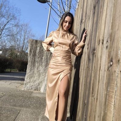 Vestido longo bege acetinado com fenda lateral e mangas compridas bufantes