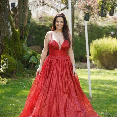 Mulher vestindo vestido longo vermelho brilhante num jardim