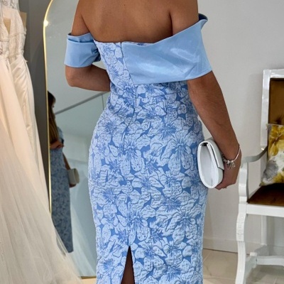 Mulher de costas com vestido azul claro e padrão floral branco