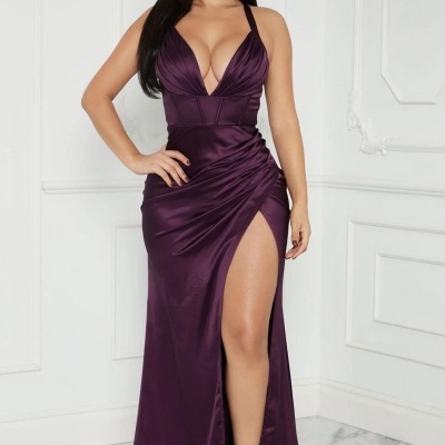 Vestido longo roxo acetinado com decote em V e abertura na perna em ambiente branco e chão de mármore