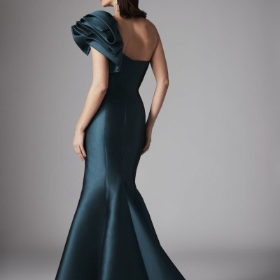 Vestido azul escuro comprido com folho volumoso num ombro.