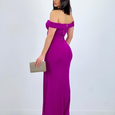 Mulher de costas a usar vestido roxo longo e carteira bege