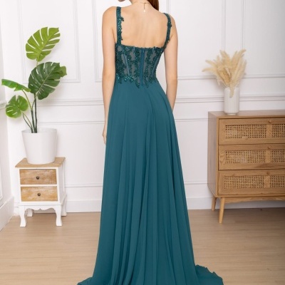 Vestido longo azul esverdeado com bordados e corpet transparente visto de costas.