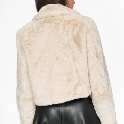 Casaco curto de pelo falso bege visto de costas