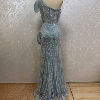 Vestido azul claro com brilhantes e um ombro só num manequim em fundo branco