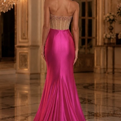 Vestido longo rosa com corpete transparente e saia de cetim em ambiente luxuoso