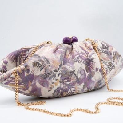 Mala de mão floral com corrente dourada sobre fundo branco