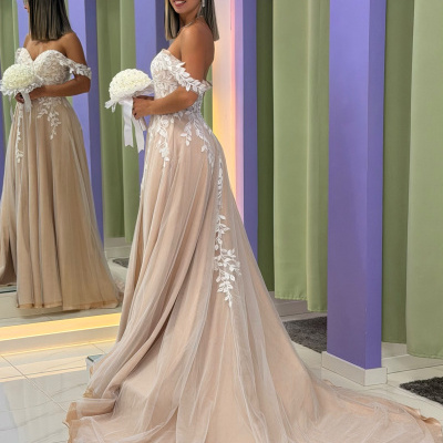 Vestido de noiva bege com aplicações de renda branca e cauda longa