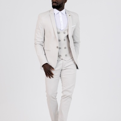 Homem com fato cinza claro, camisa branca e sapatos cinza em fundo branco