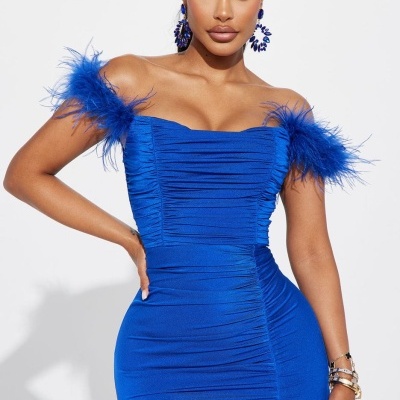 Vestido azul justo com ombros com penas, racha frontal, usado por mulher em fundo branco