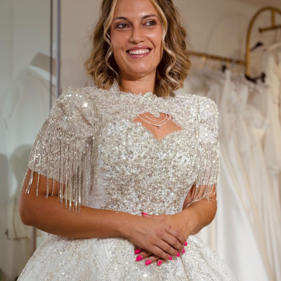 Vestido de noiva branco brilhante com franjas prateadas em mulher sorridente