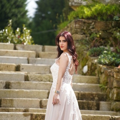 Mulher com vestido de noiva branco de renda em escadaria de pedra