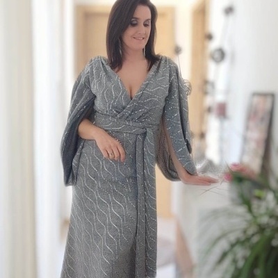 Vestido longo cinzento com padrão em linha ondulada branca e mangas largas.