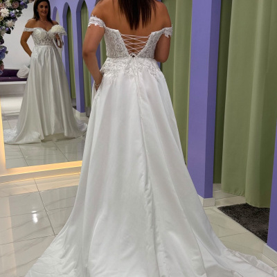 Vestido de noiva branco com detalhes rendados visto de costas em provador