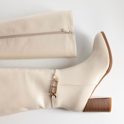 Bota feminina alongada creme com salto quadrado e fivela dourada