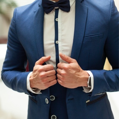 Homem a vestir fato azul com gravata borboleta azul e camisa branca