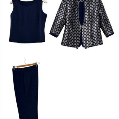 Conjunto de roupa com top azul escuro, casaco estampado azul e branco, e calças azuis em cabides