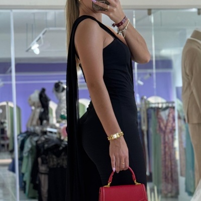 Mulher com macacão preto e mala vermelha ENRICO COVERI em loja de roupas