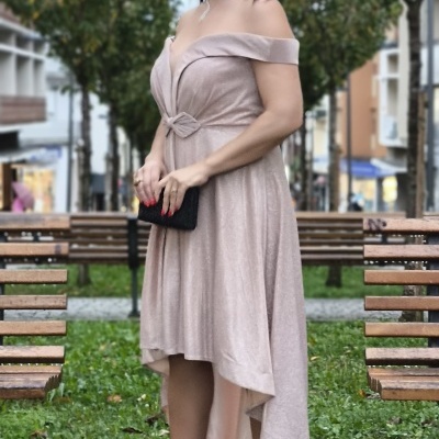 Mulher com vestido rosa claro de festa em parque urbano