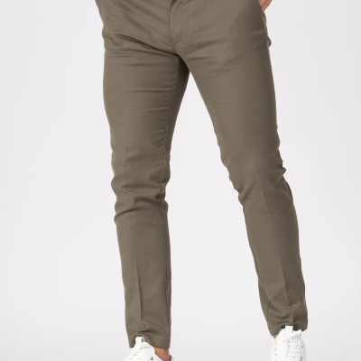 Calças castanho-mesclado justas com ténis brancos e botão azul escuro