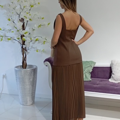 Vestido castanho de duas partes com corpete e saia plissada vista de costas em ambiente interior moderno