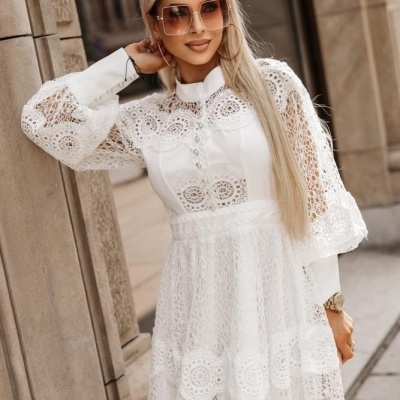 Vestido branco em renda com mangas compridas e detalhes rendados usados por mulher com óculos de sol