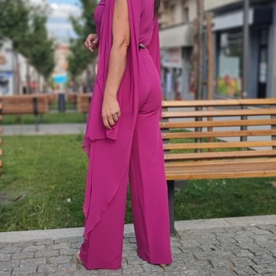 Mulher com roupa fúcsia em zona urbana com bancos e árvores