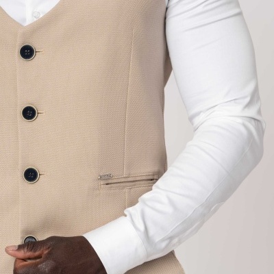 Colete bege com botões pretos e camisa branca