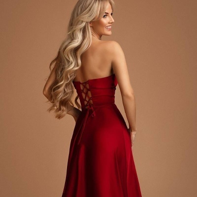 Vestido longo vermelho sem alças com amarração nas costas em fundo castanho