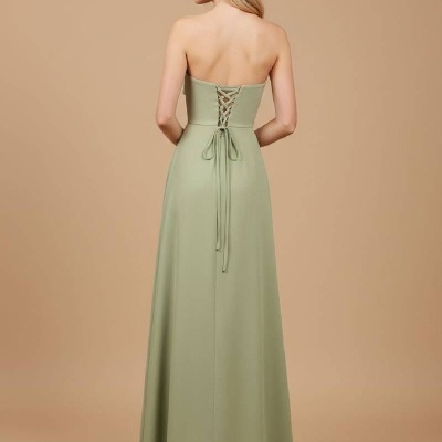 Vestido comprido verde claro com laçada nas costas em fundo bege