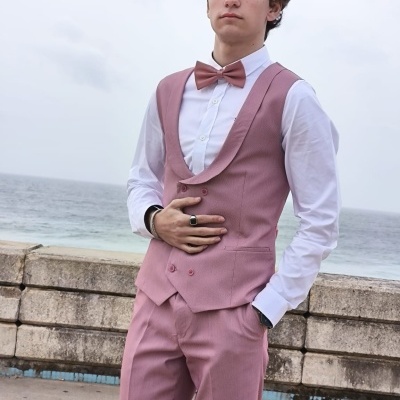 Jovem com fato rosa e camisa branca junto ao mar