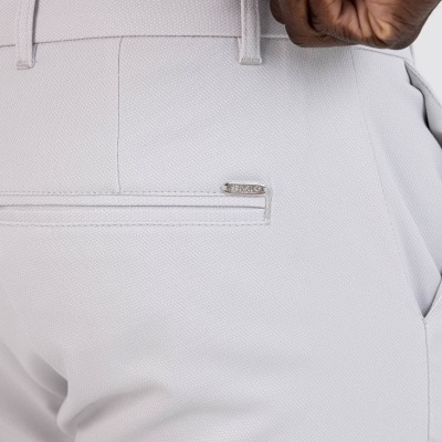 Calças brancas texturizadas com fecho metálico ELLESSE e bolso traseiro.