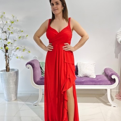Mulher com vestido vermelho comprido e banco roxo