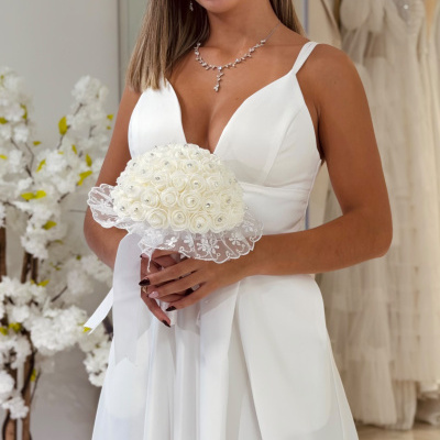 Mulher com vestido de noiva branco, bouquet branco e acessórios prateados