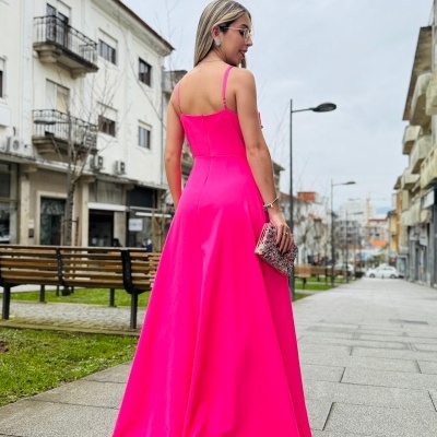 Vestido longo rosa vibrante de alças finas num ambiente urbano