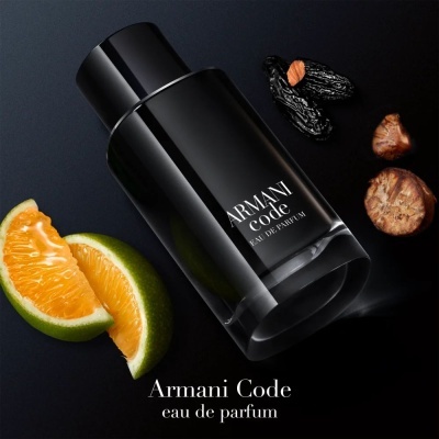 Frasco de perfume Armani Code com frutas e sementes em fundo escuro