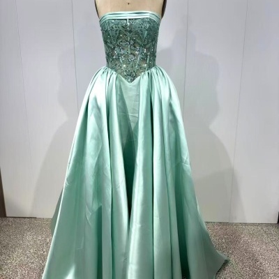 Vestido verde-água bordado com saia longa acetinada num manequim.