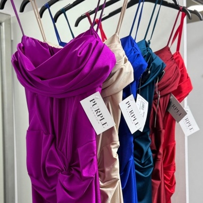 Vestidos coloridos acetinados com alças finas em cabides