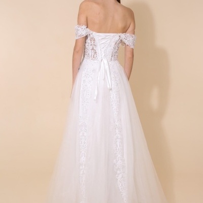 Vestido branco de noiva com detalhes em renda e ombros descobertos visto de costas