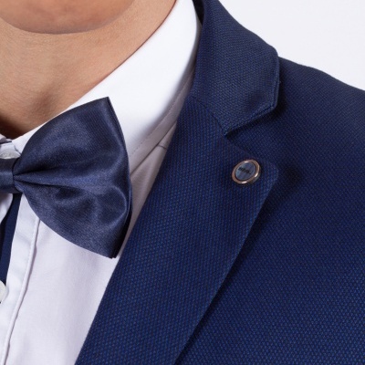 Detalhe de fato azul escuro com gravata borboleta azul e camisa branca
