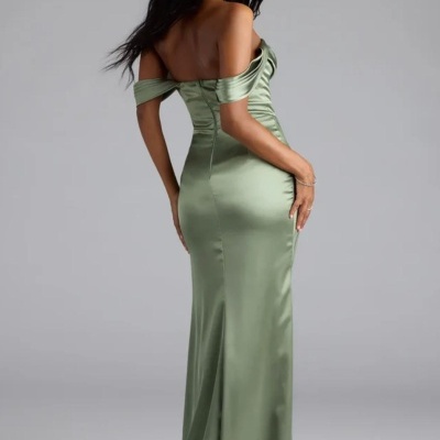 Vestido longo verde acetinado com decote ombros caídos em fundo cinzento