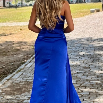 Vestido comprido azul royal em tecido acetinado, mulher de costas num parque