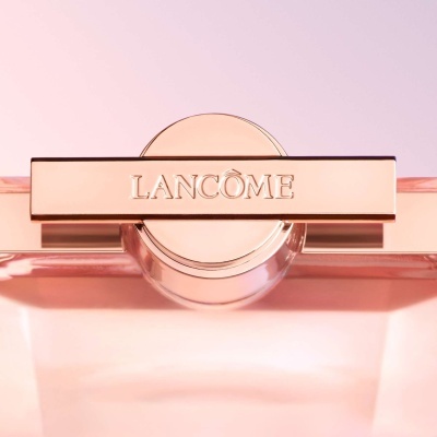 Frasco de perfume Lancôme com tampa dourada e fundo rosa