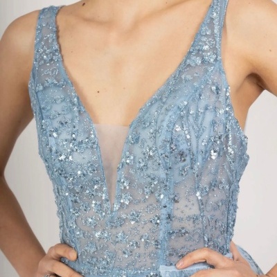 Vestido azul claro com aplicações de lantejoulas e bordados, decote em V profundo e tecido transparente