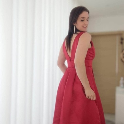 Vestido longo vermelho com decote nas costas num ambiente interior