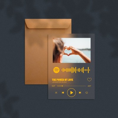 Cartão digital com imagem, código Spotify e título THE POWER OF LOVE junto a envelope castanho