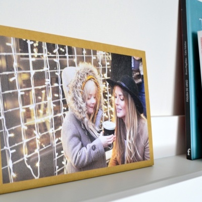 Tela decorativa com imagem de duas mulheres sorrindo com luzes ao fundo, moldura amarela