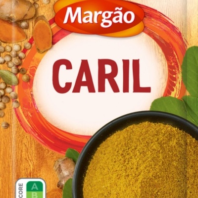 Pacote de caril Margão com especiarias ao redor e uma tigela contendo caril em pó