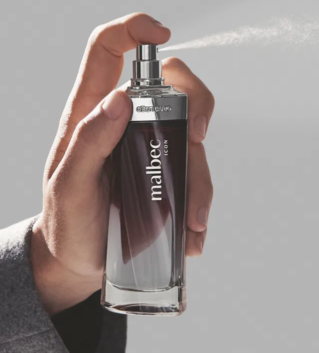 63139 Malbec Icon Edt 100ml Frasco de perfume Malbec Icon segurado por uma mão num fundo cinzento